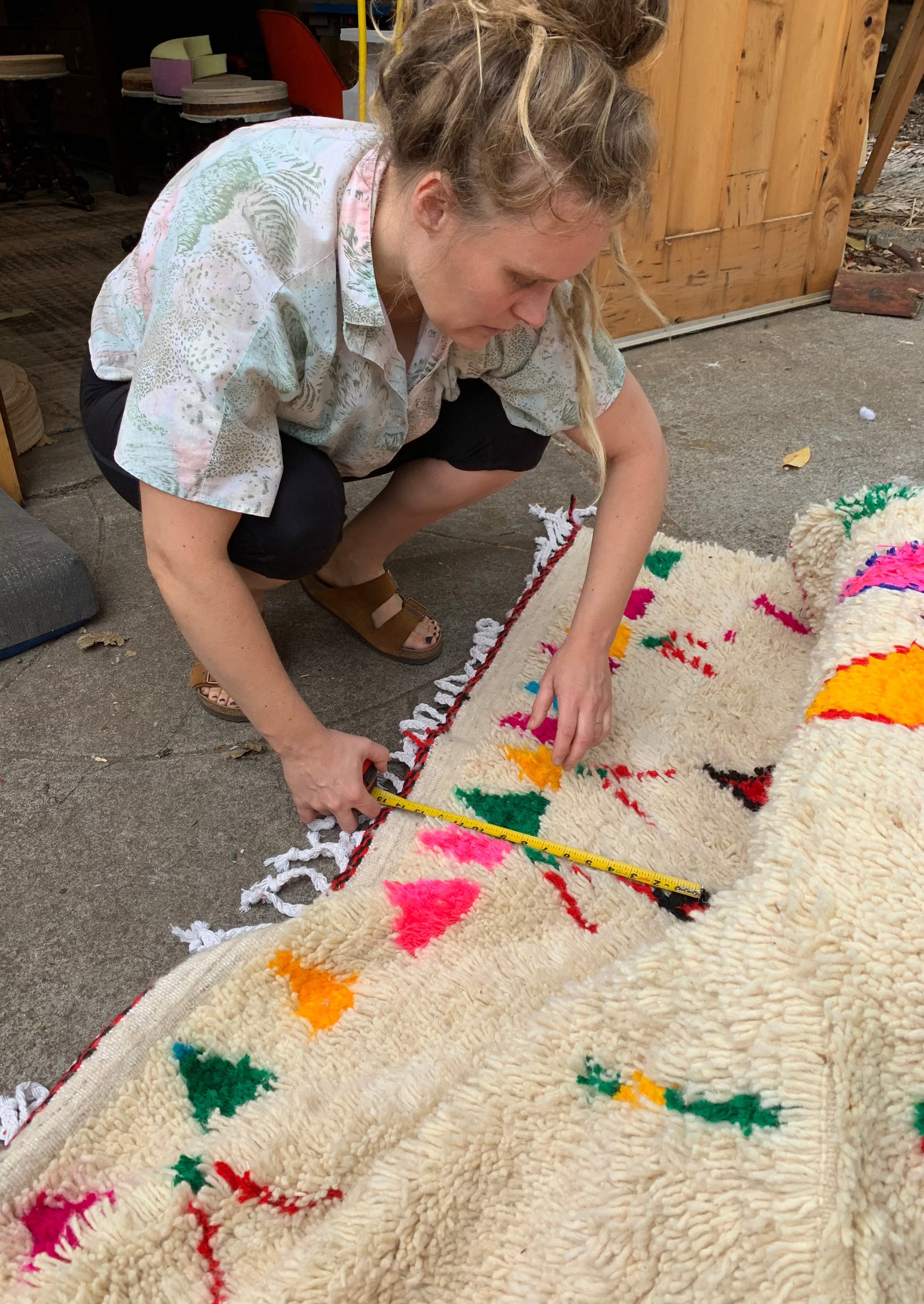 upholstery artist anne williams measures moroccan rug to prepare for upholstering the chaise lounge. french artist now works from her studio in portland oregon