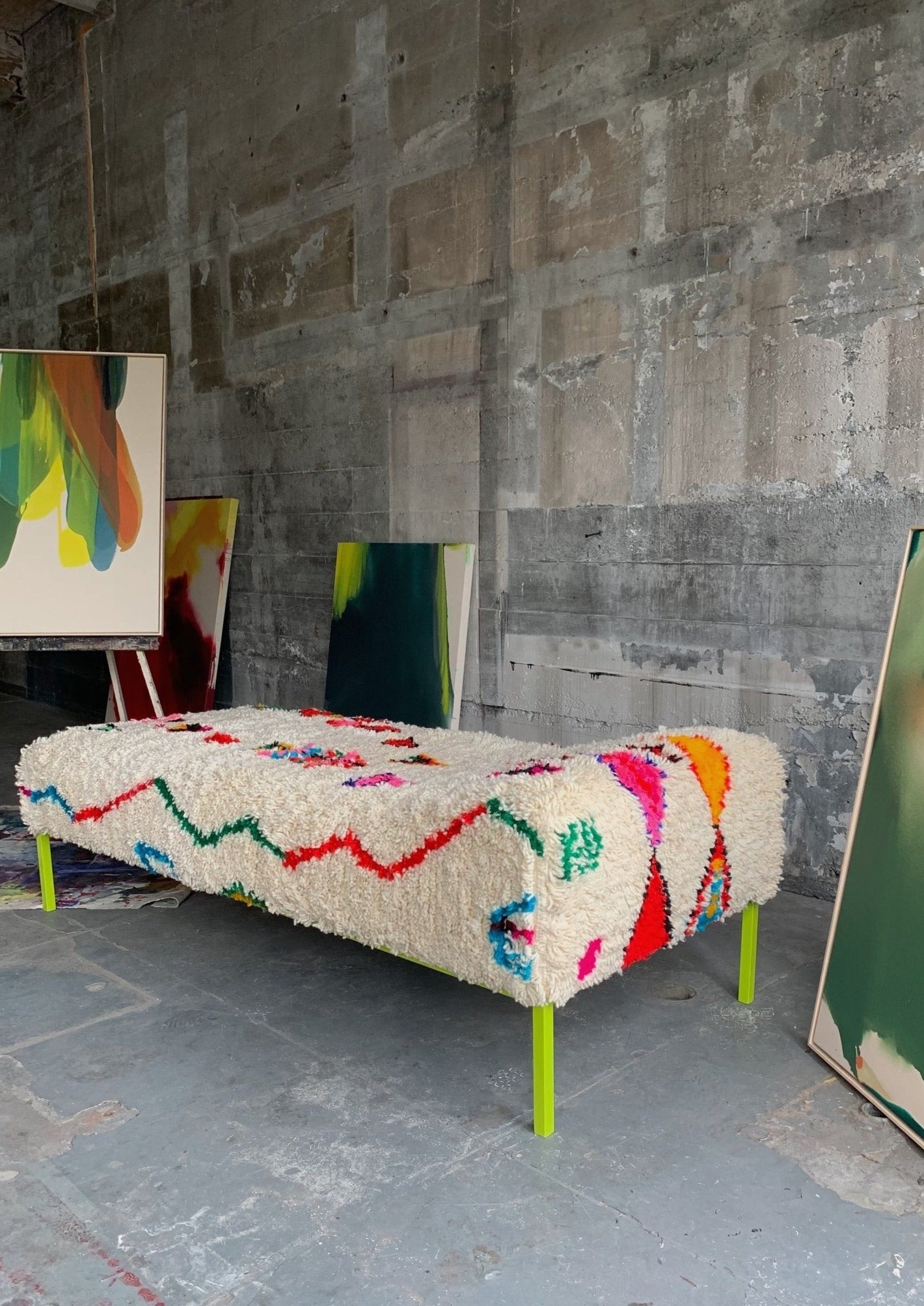angle of day bed showing off its electric powder coated green legs and moroccan rug upholstered for a fresh look inside urban art studio