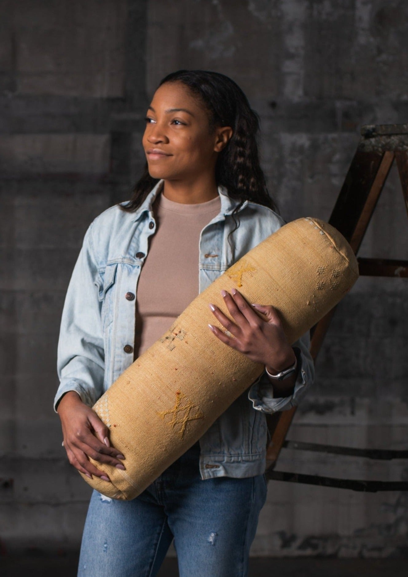 African American girl gazing off in the distance while she holds her favorite yellow pillow made by artisans of morocco 